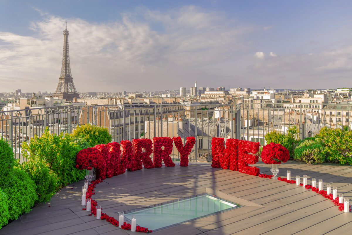 Marry Me' letters with silk flowers, flameless candles, and scattered rose petals from 50+ roses