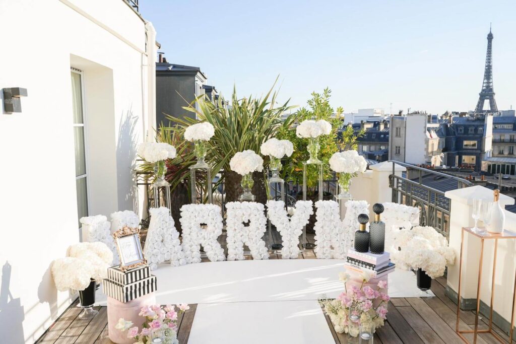 A customized "Marry Me" setup on a private rooftop at the Marignan Hotel, featuring an elegant design with a breathtaking Eiffel Tower view, creating the ultimate romantic proposal setting.